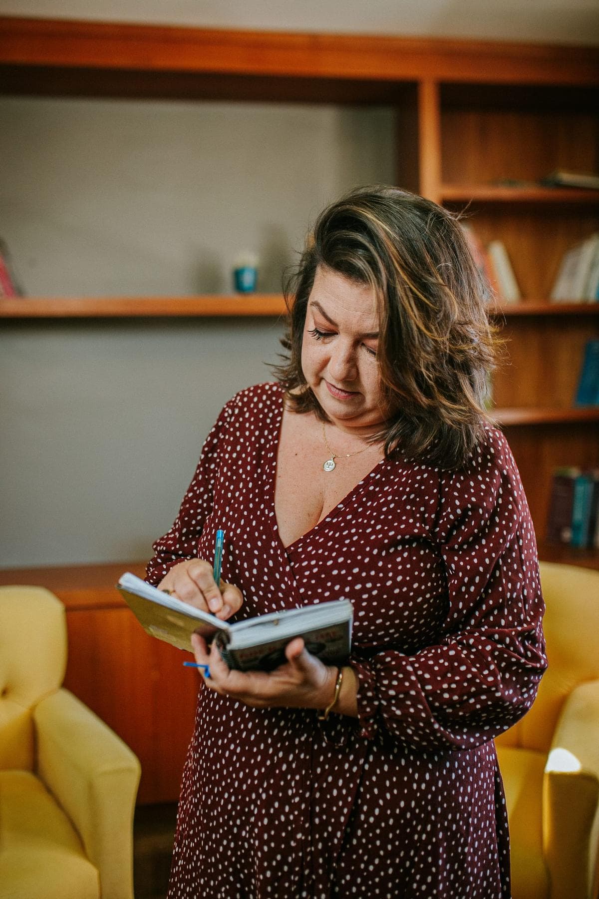 Michelle anotando em caderno no consultório